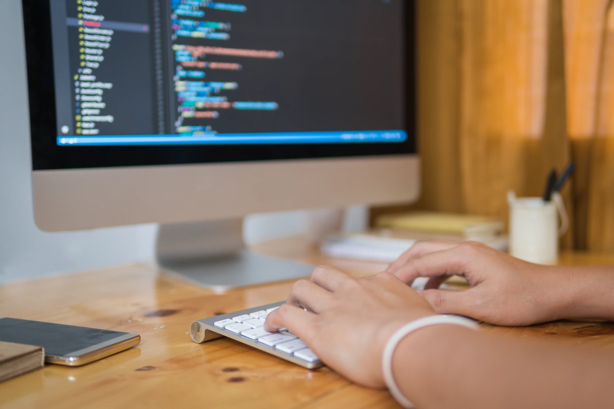 Person writing code on a Mac computer.