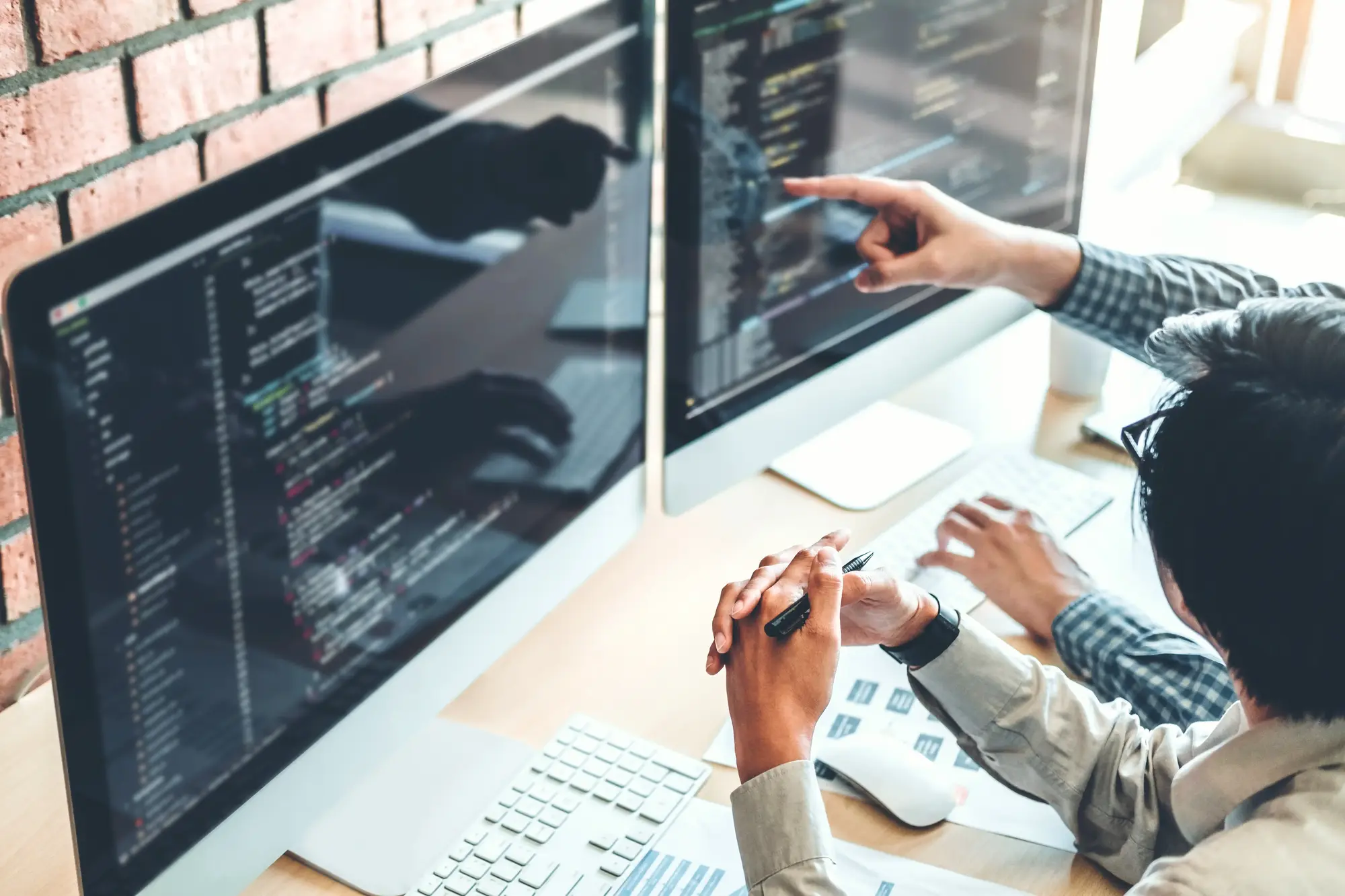 Employees sharing Mac computer to review codebase together