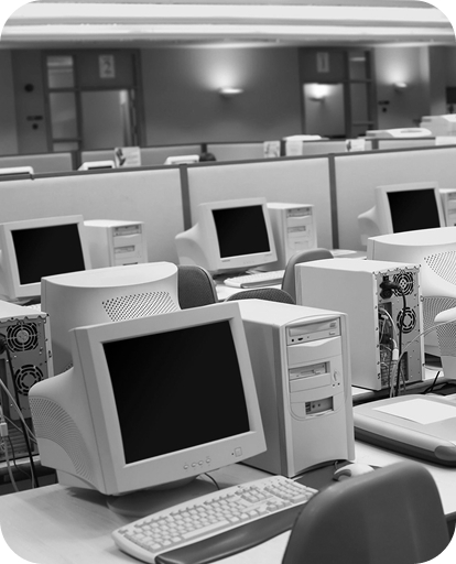 Office space full of old computers; black and white